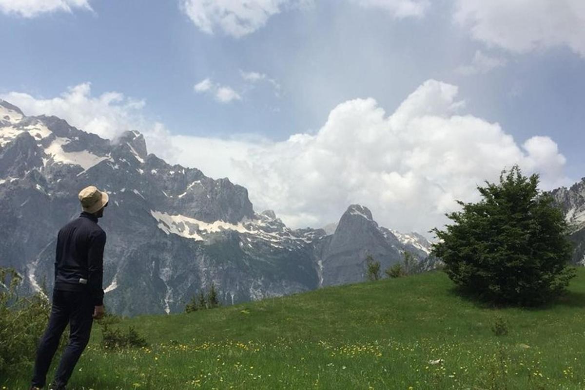 un uomo in piedi su una collina che guarda una montagna