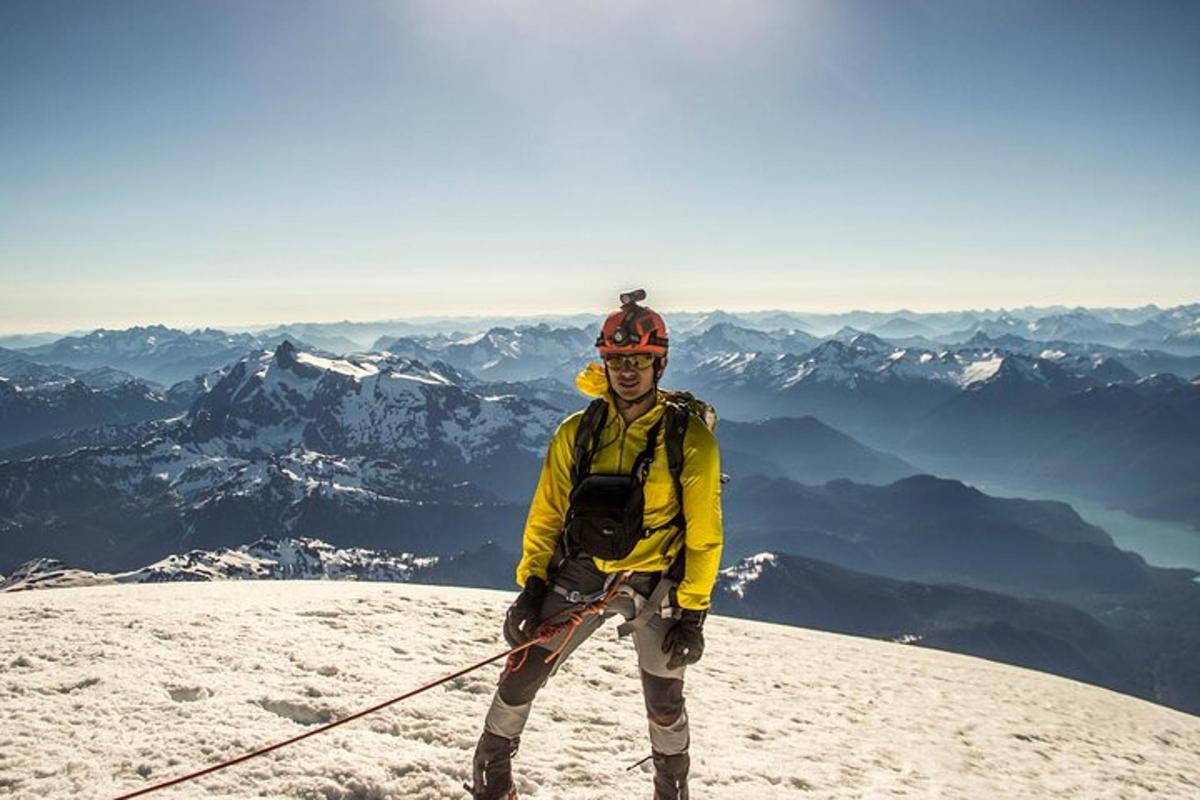 un home dret al cim d'una muntanya coberta de neu