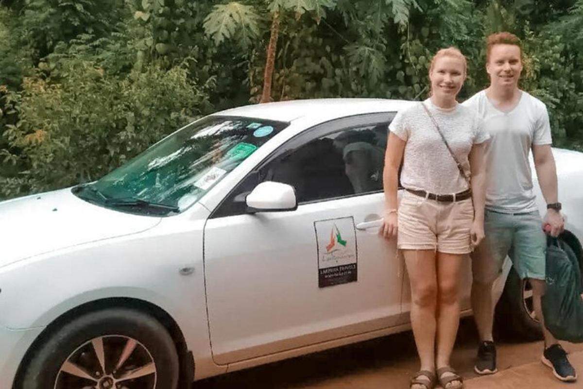 zwei Personen stehen vor einem weißen Auto