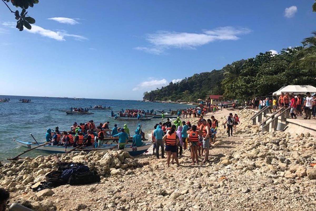 一群人在海滩上，水里有船