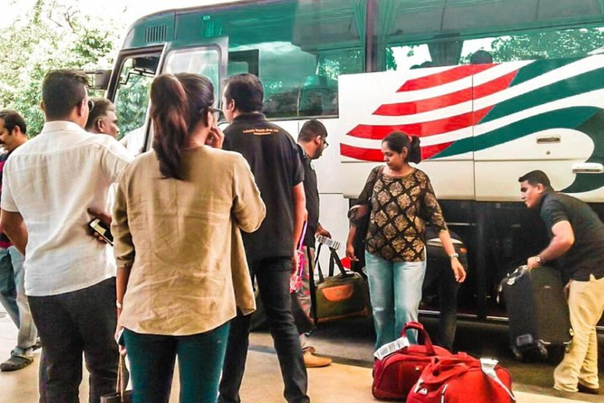 isang grupo ng mga tao na nakatayo sa labas ng bus