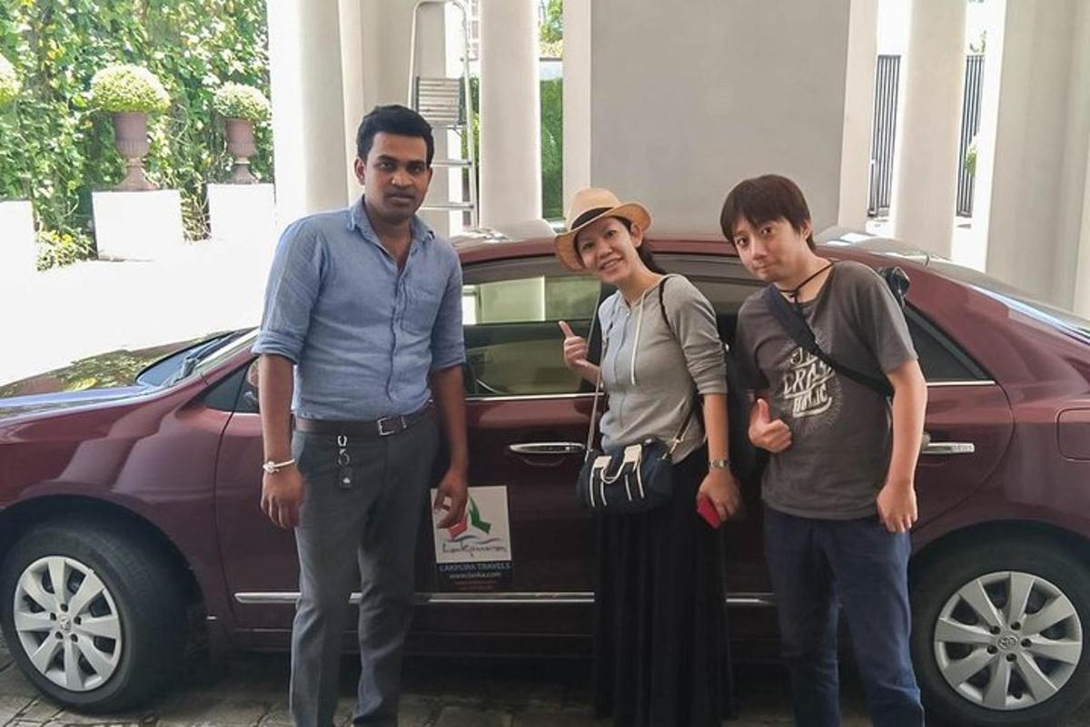 um grupo de três homens parados na frente de um carro