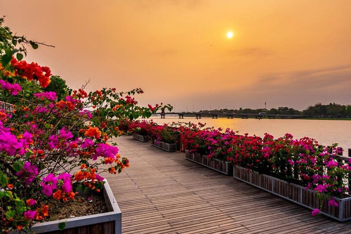 a row of flowers on a boardwalk near the water