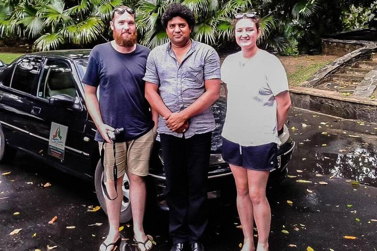 a group of three people standing next to a car