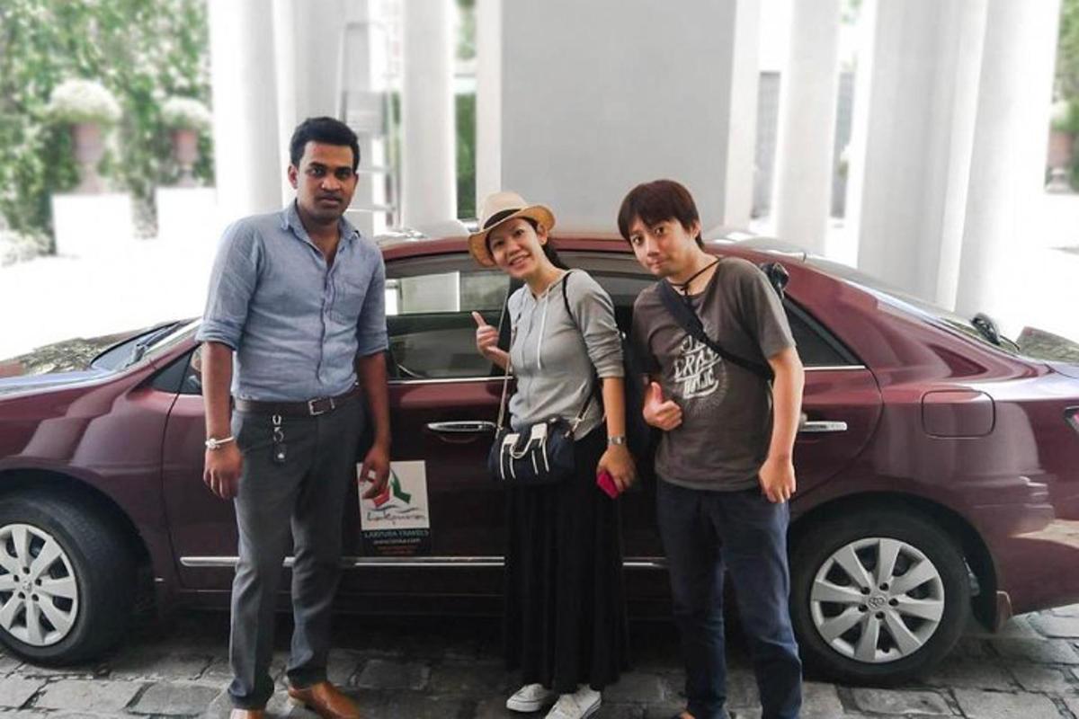 a group of three men standing in front of a car