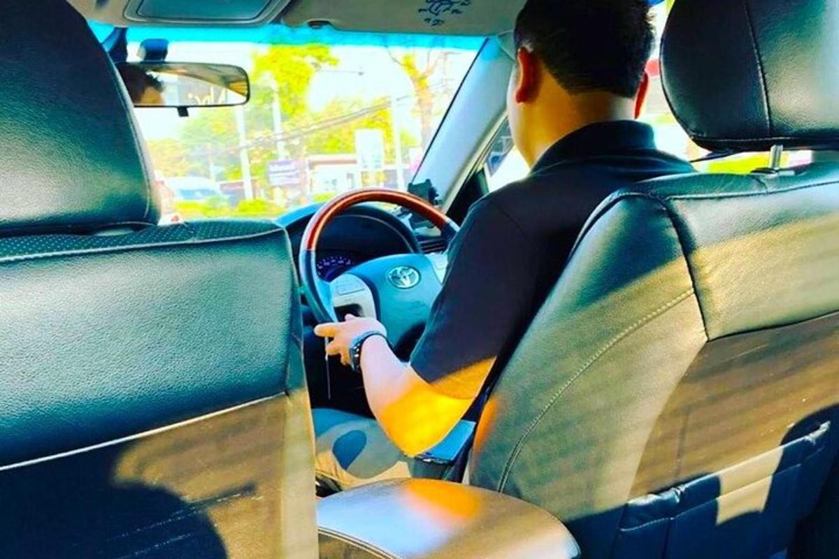 un uomo che guida un'auto su una strada