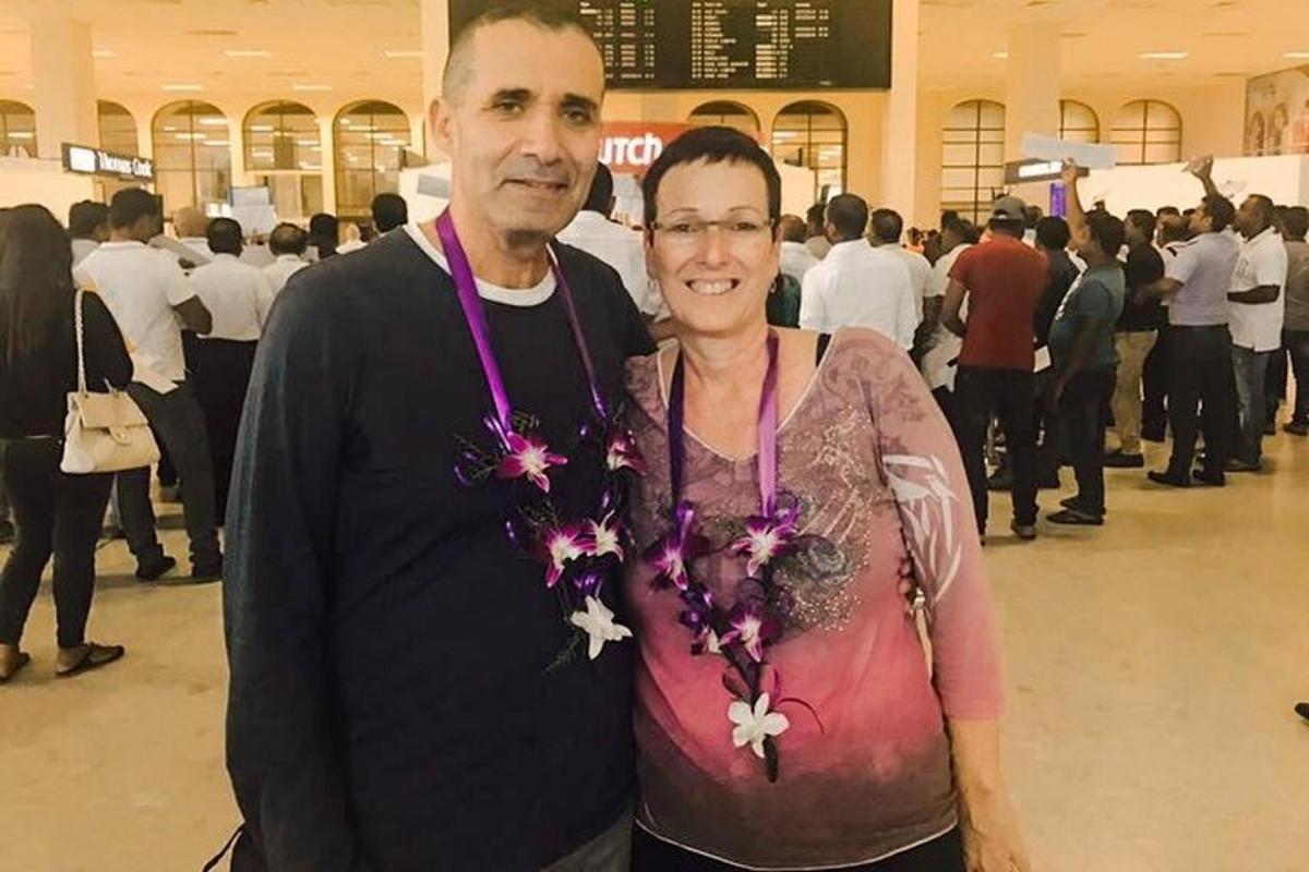 un uomo e una donna posano per una foto in un centro commerciale