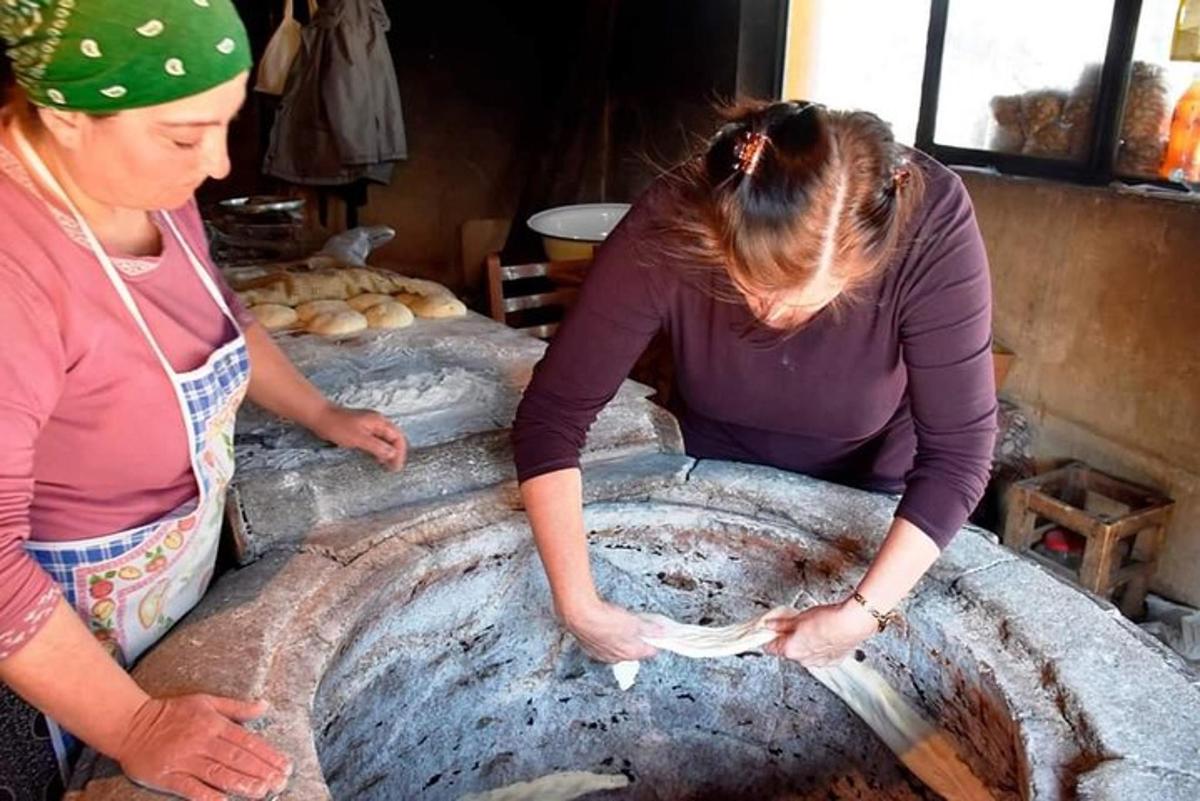 due donne stanno preparando il pane in un forno