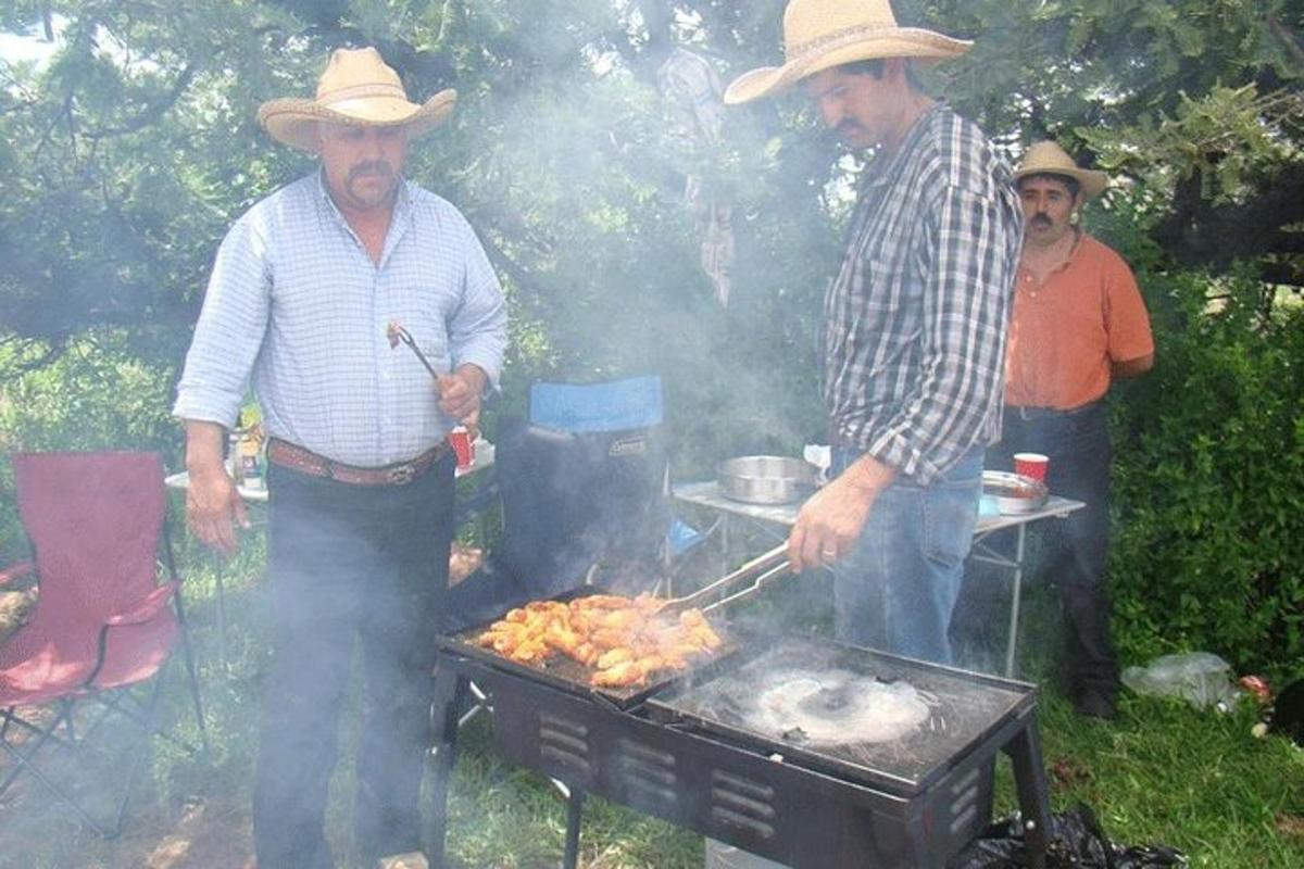 skupina mužů vařících jídlo na grilu
