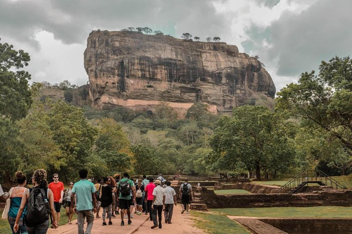 a group of people walking in front of a mountain