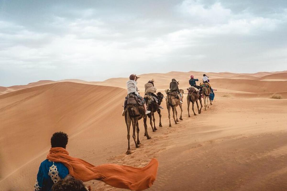 a group of people riding camels in the desert