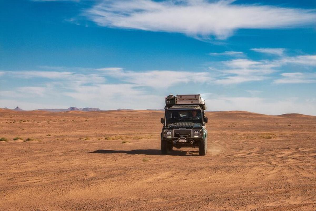 a truck driving on a dirt road in the desert