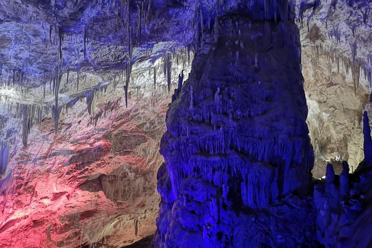un dipinto di una grotta con rocce blu e rosse