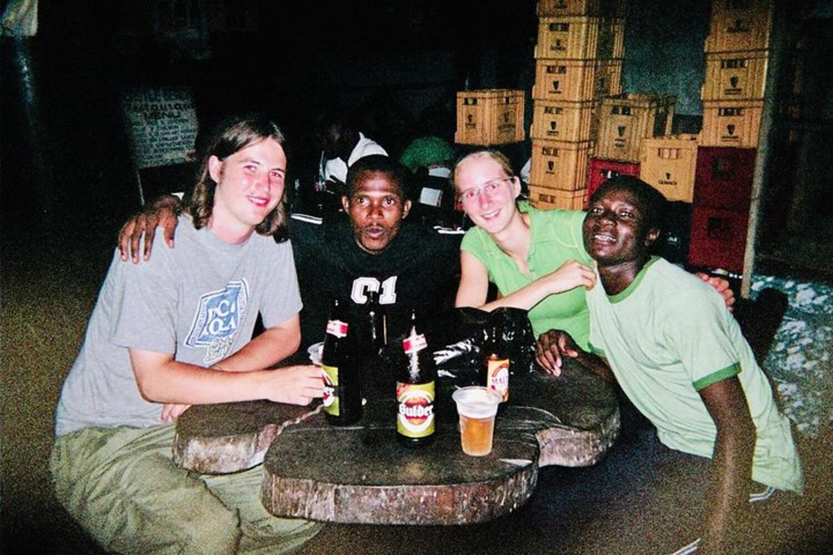 a group of people sitting around a table with beer bottles
