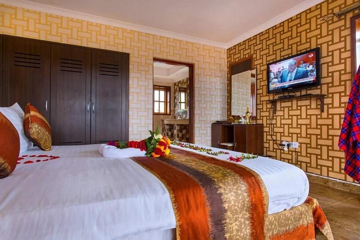 Un dormitorio con una cama grande con un televisor en la pared.