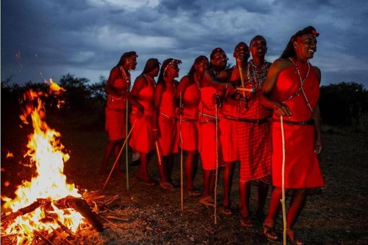 een groep vrouwen die rond een vuur staan