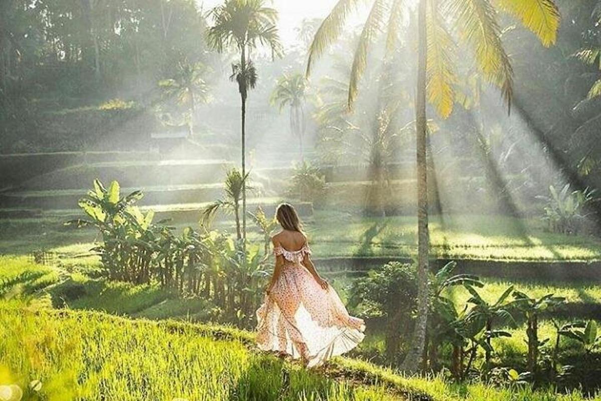 una mujer caminando por un campo con palmeras