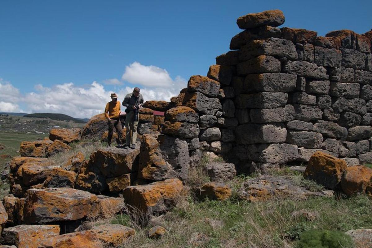 duas pessoas em pé no topo de um muro de pedra