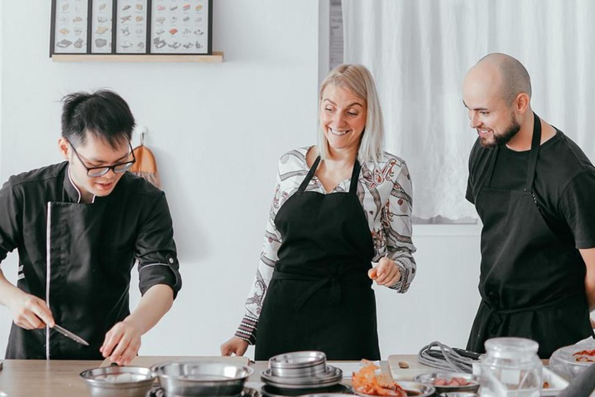 a group of three people in a kitchen preparing food