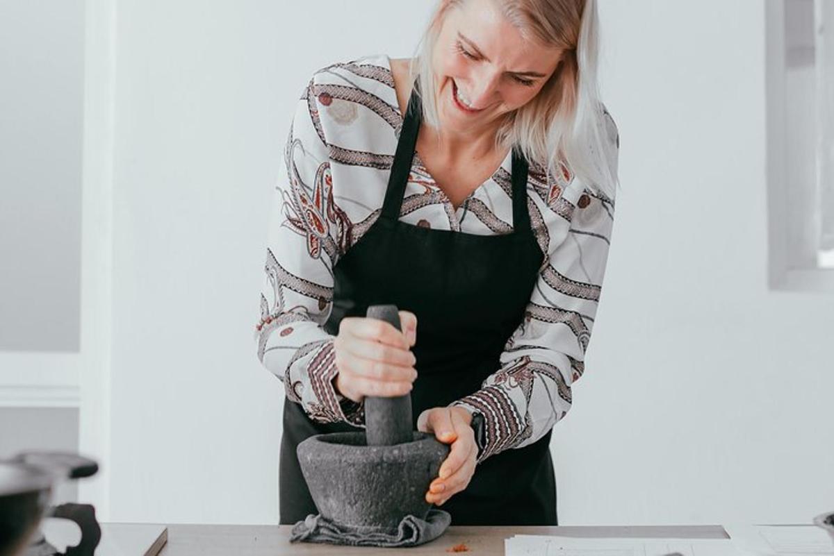 a woman in a kitchen making a vase