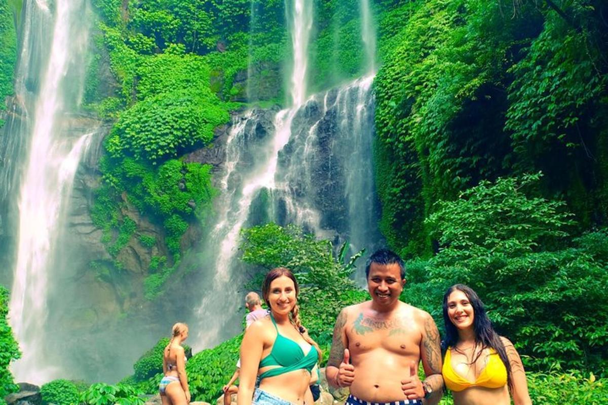 tiga orang berdiri di hadapan air terjun