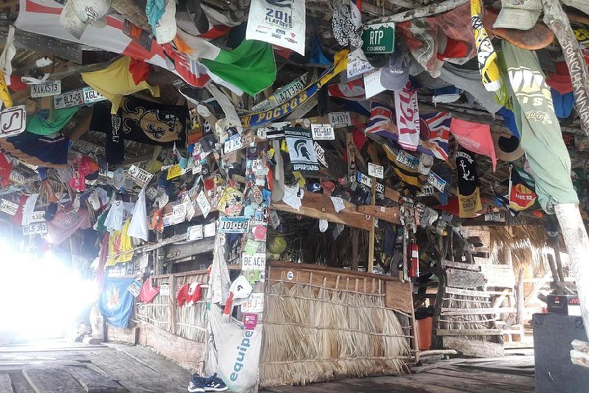 egy szoba, amelynek falát rengeteg kalap és felirat tölti meg