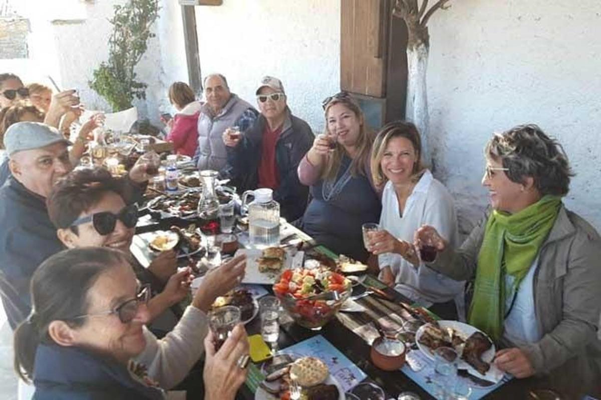 Un grupo de personas sentadas alrededor de una mesa comiendo comida