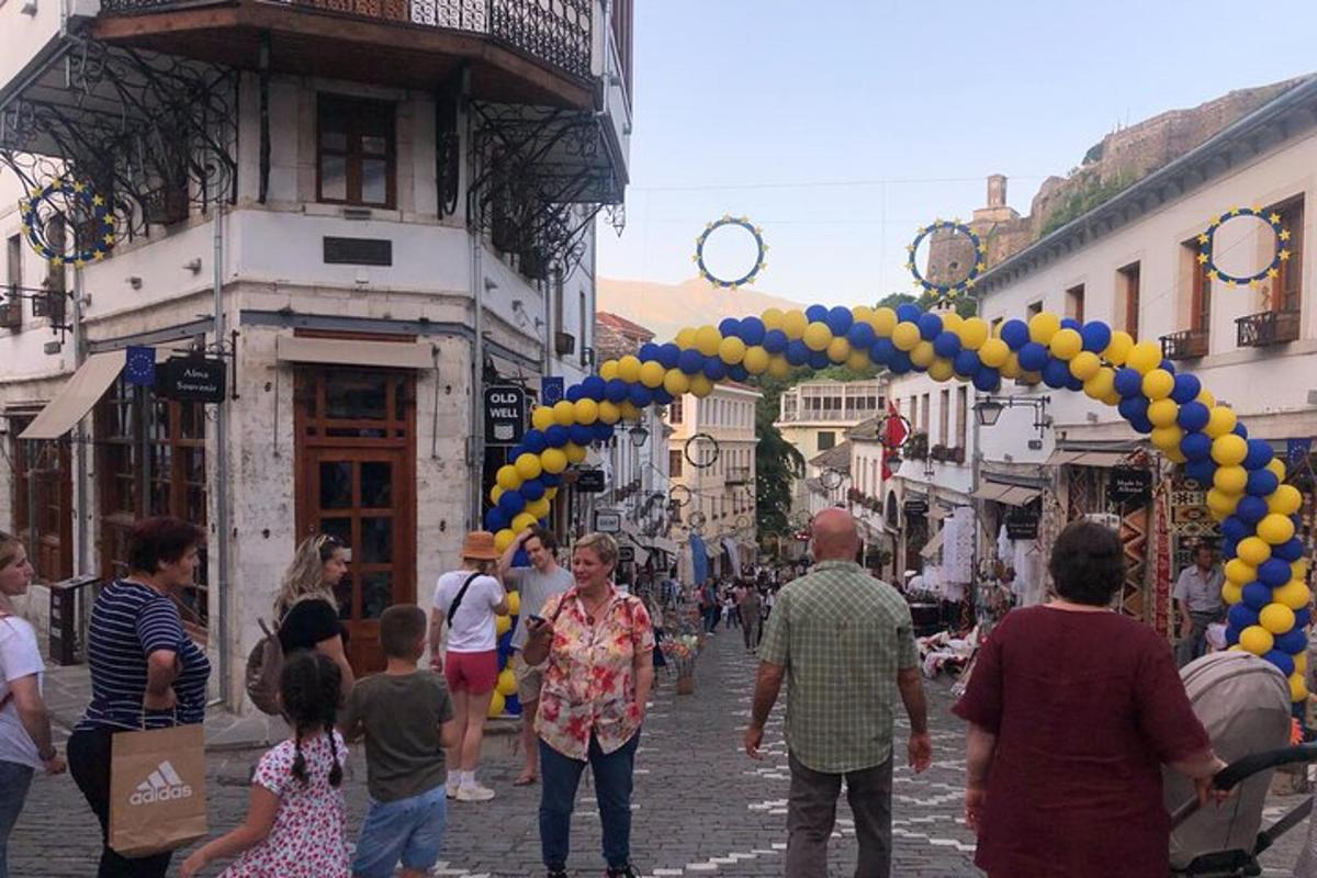 en gruppe mennesker som går nedover en gate med en haug med ballonger