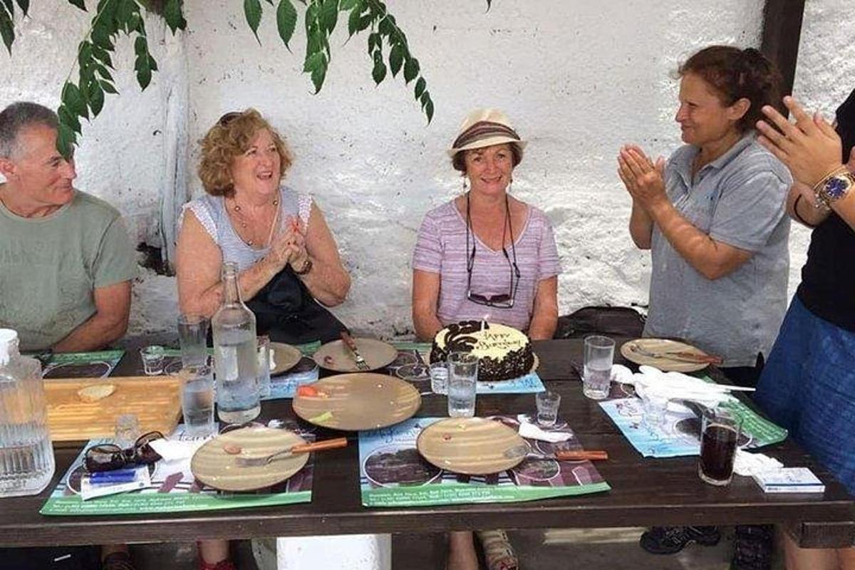 Un grupo de personas sentadas alrededor de una mesa con un pastel.