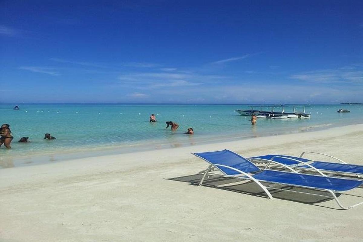 una spiaggia con una sedia e persone in acqua
