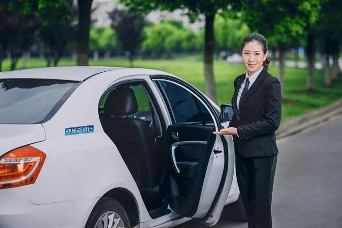 a woman in a suit standing next to a white car