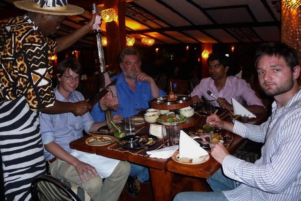 un gruppo di uomini seduti attorno a un tavolo che mangiano cibo