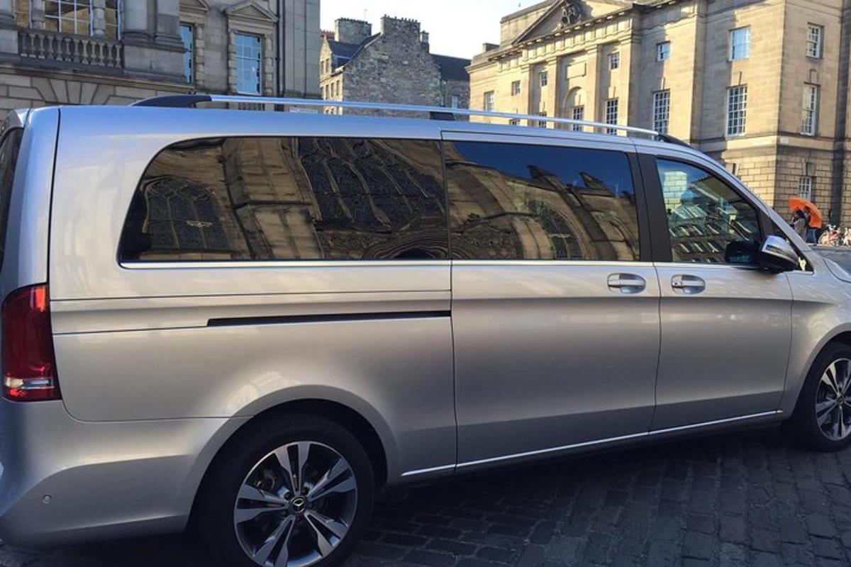 a silver van is parked on a city street