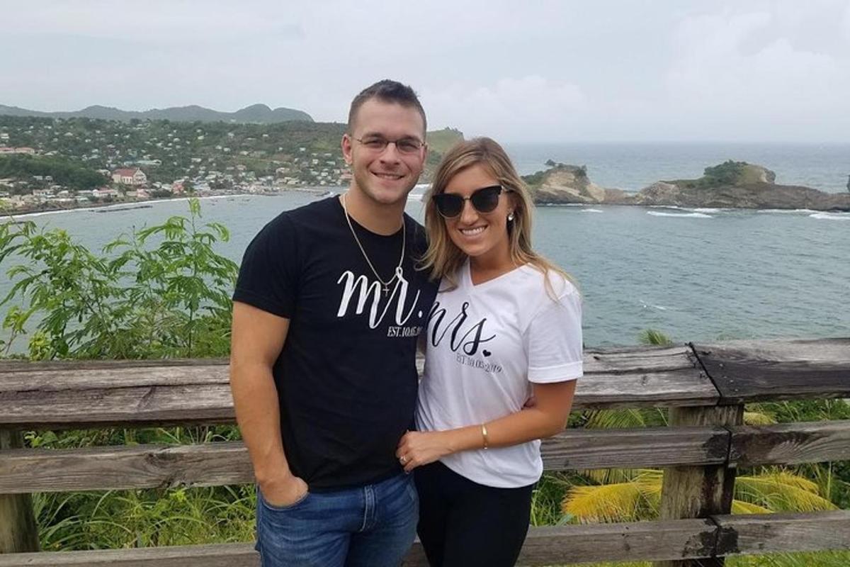 a man and woman standing in front of the ocean