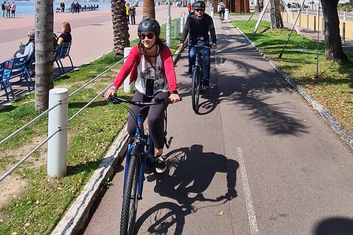 a woman riding a bike down a sidewalk