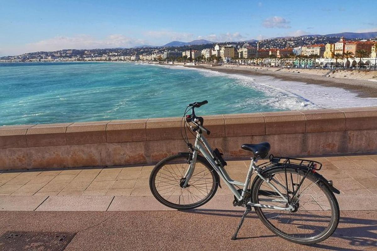 a bike parked on a sidewalk next to a beach