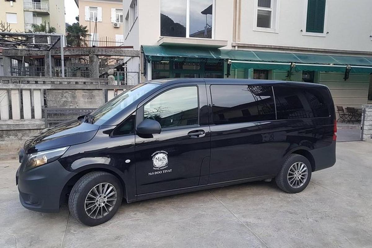建物の前に駐車された小さな黒いバン