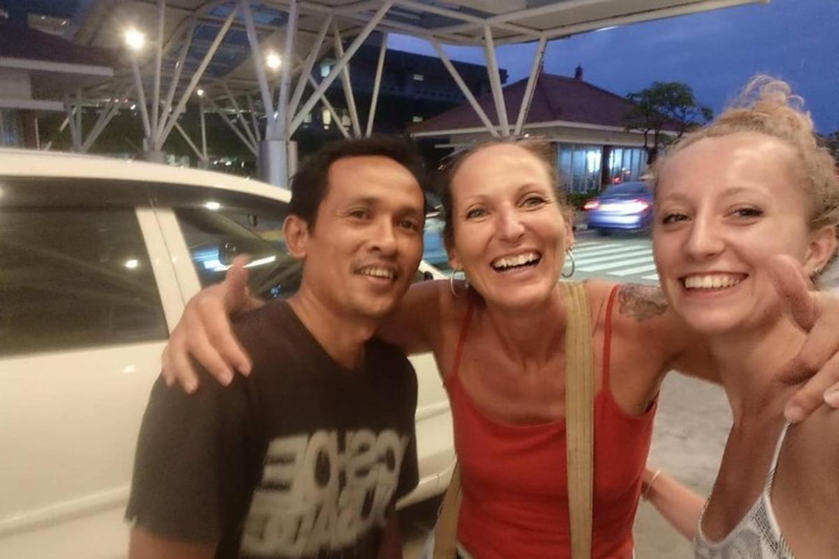 un uomo e due donne in piedi accanto a un'auto
