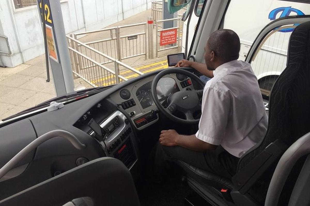 a man sitting in the drivers seat of a bus