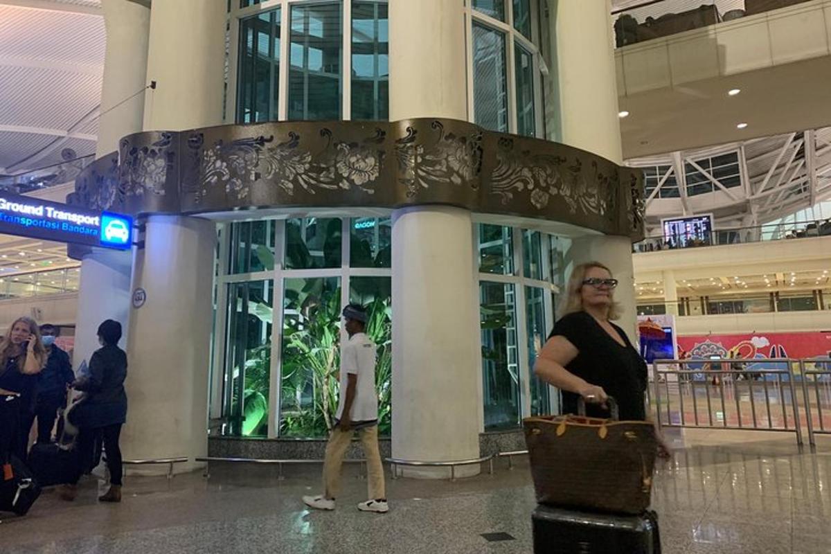 uma mulher parada em um aeroporto com uma mala