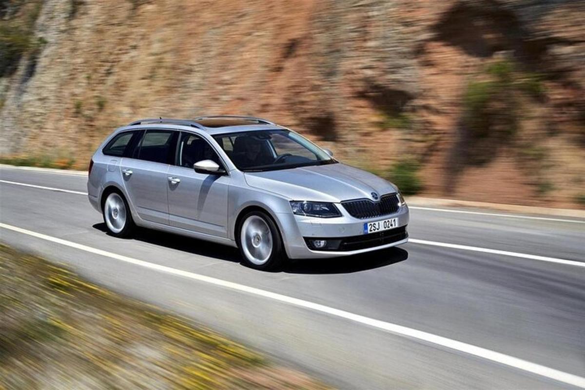 a silver car is driving down a road