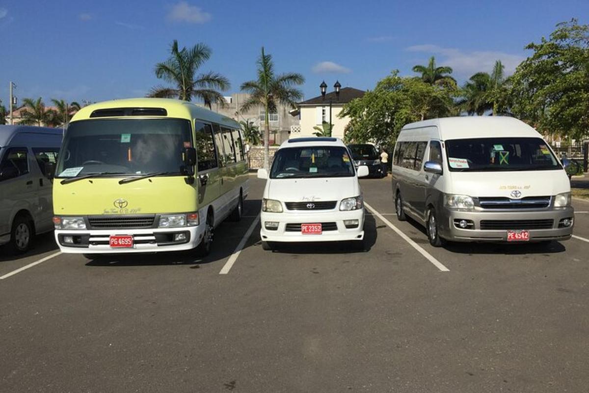 tre autobus e un furgone parcheggiati in un parcheggio