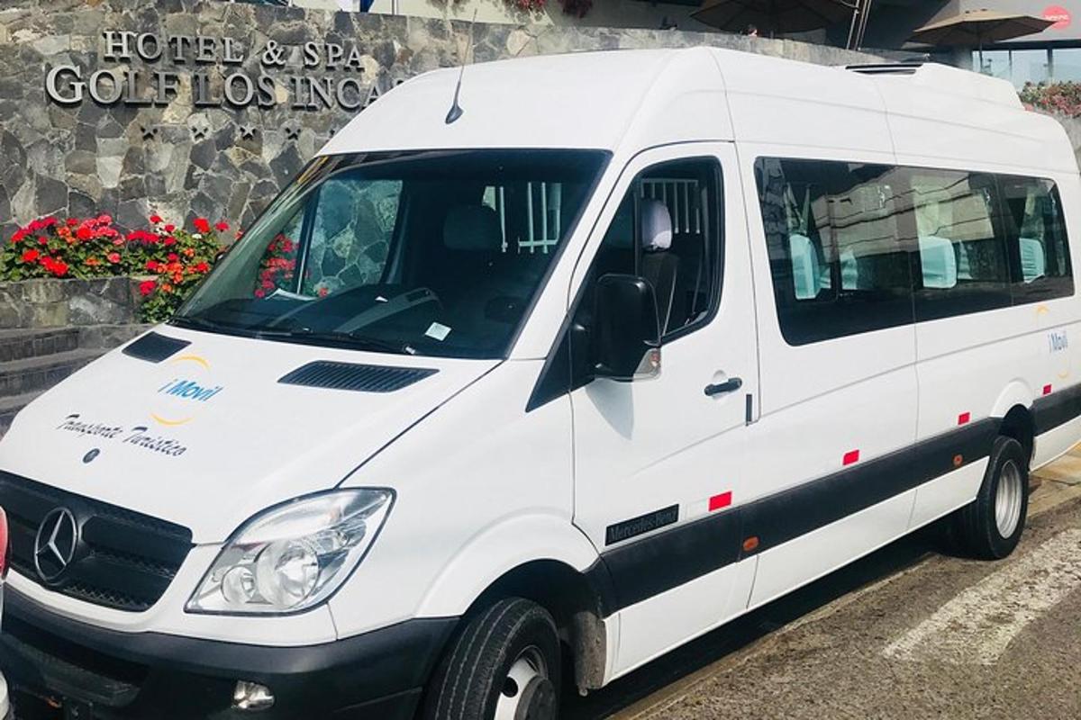 baltas mikroautobusas, pastatytas priešais pastatą