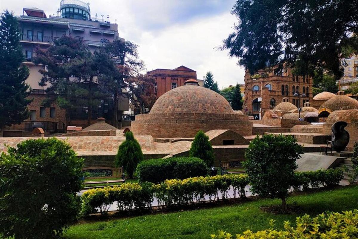 un edifici amb cúpules i arbustos en un parc