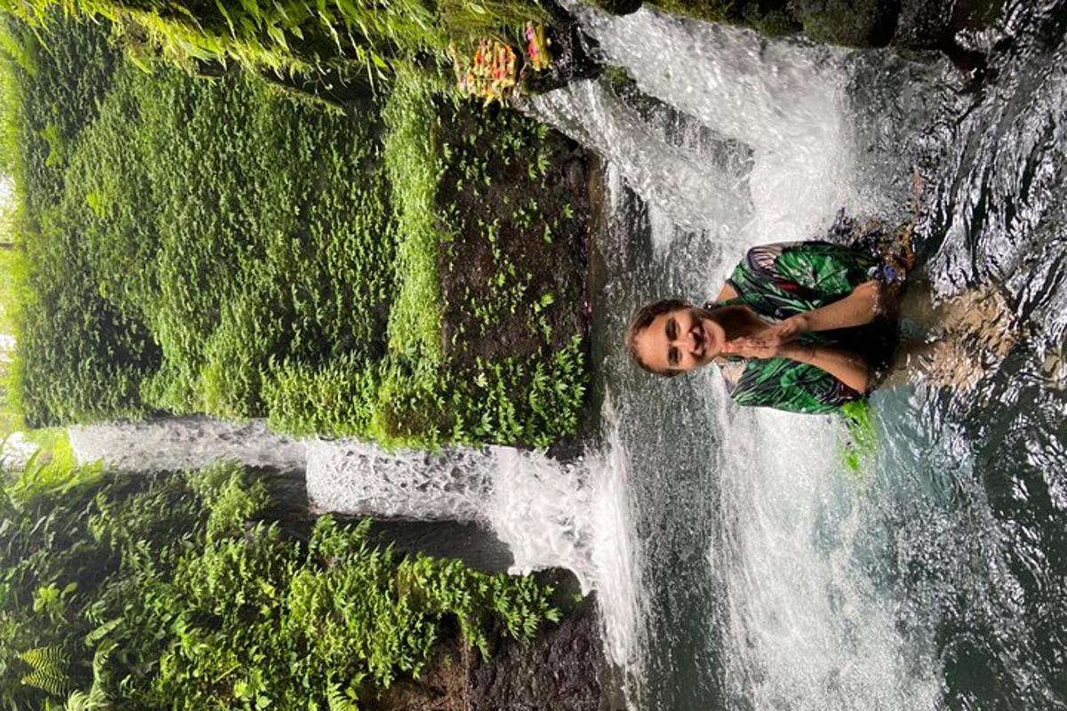 un uomo in piedi accanto a una cascata