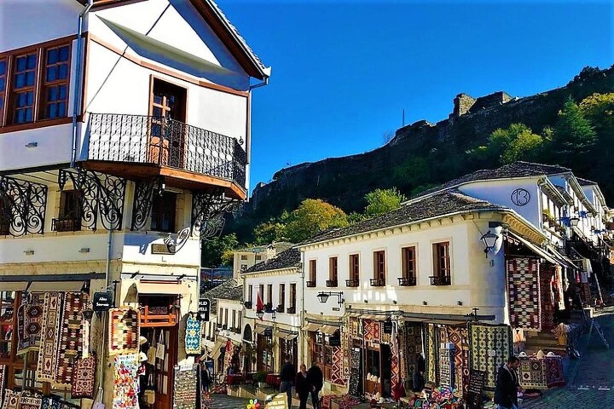 a group of buildings next to a street with shops