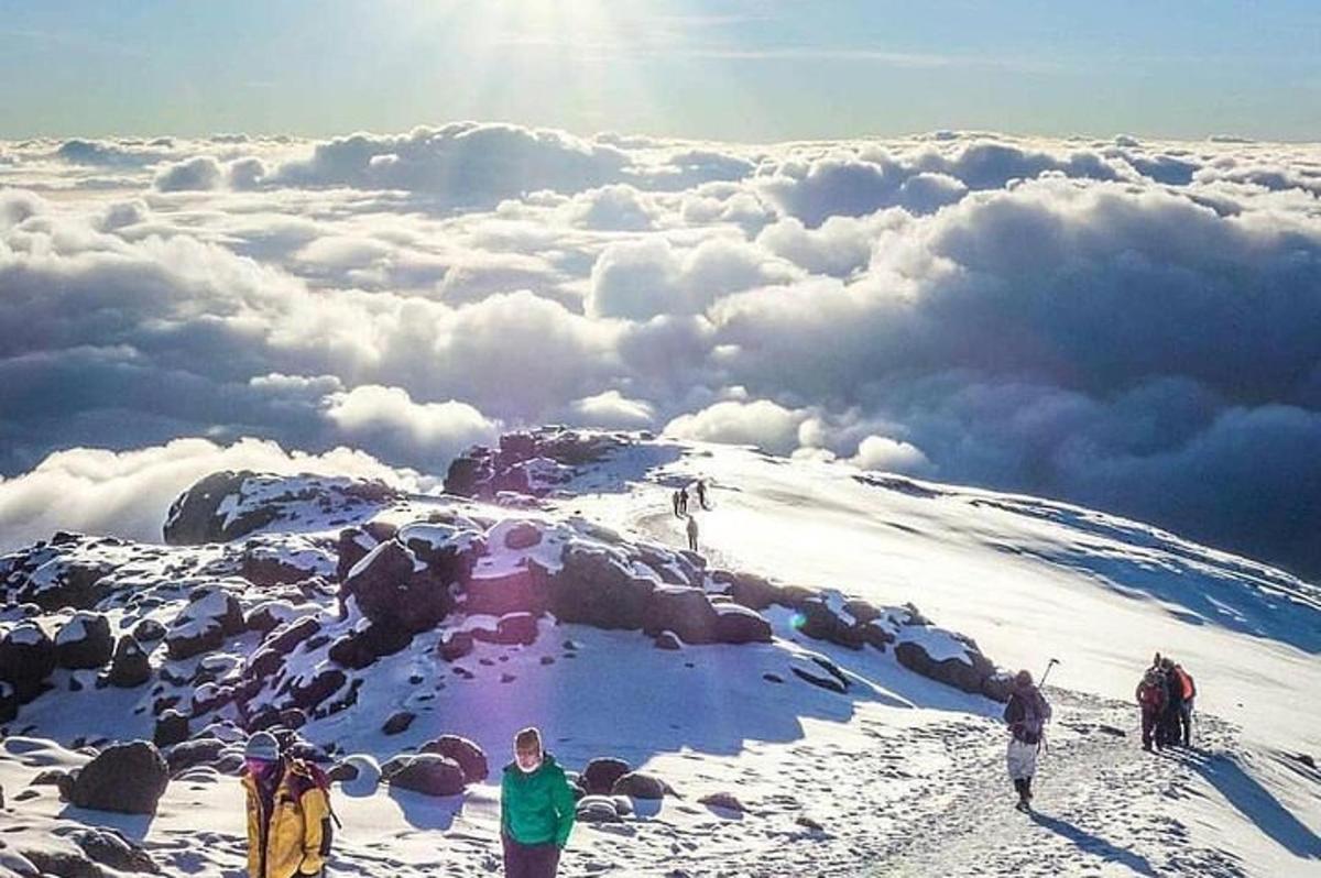 雪に覆われた山の頂上に立つ人々のグループ