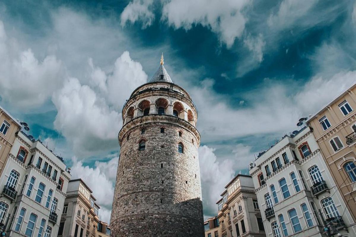 visok opečnat stolp z zgradbo v ozadju