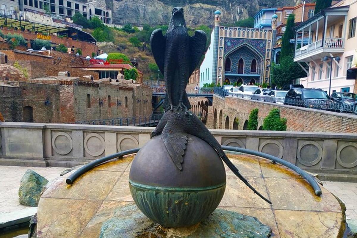 o statuie a unei păsări așezate deasupra unei mingi