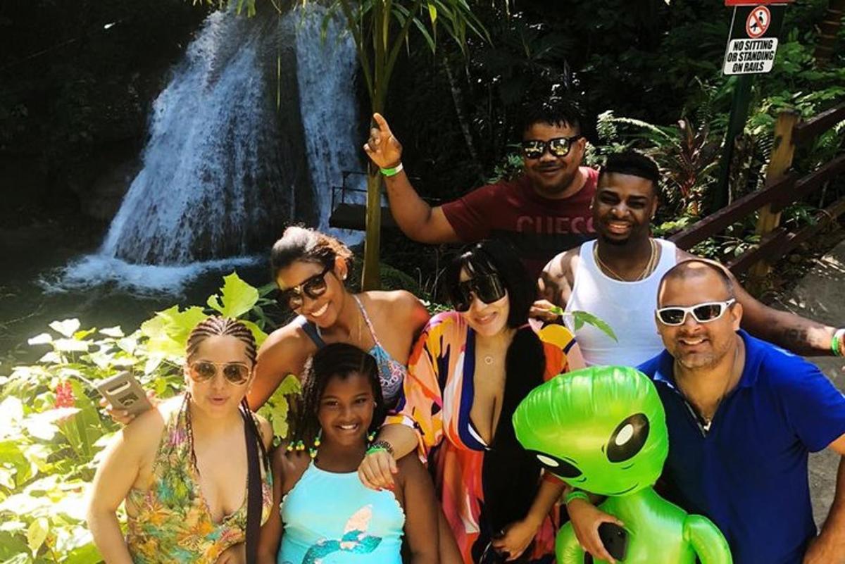 a group of people standing in front of a waterfall